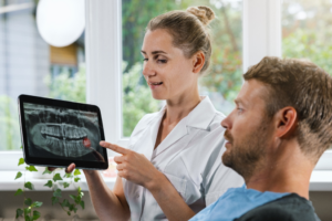 a dental assistant and patient reviewing an X-ray image